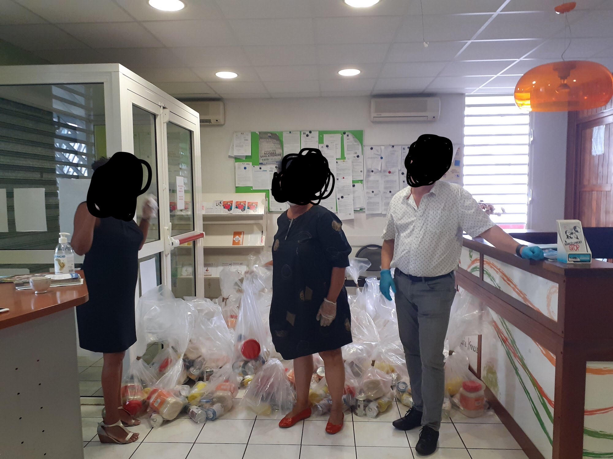 Des élus de St-Denis posant devant des colis alimentaires à l'intérieur des locaux du CCAS. Derrière eux, les colis très reconnaissables dans leurs sacs transparents et le scotch marron (Photo Facebook mairie de St-Denis)