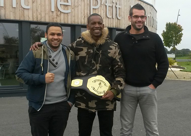 Ludovic Nassibou, au centre, avec sa ceinture de titre mondial