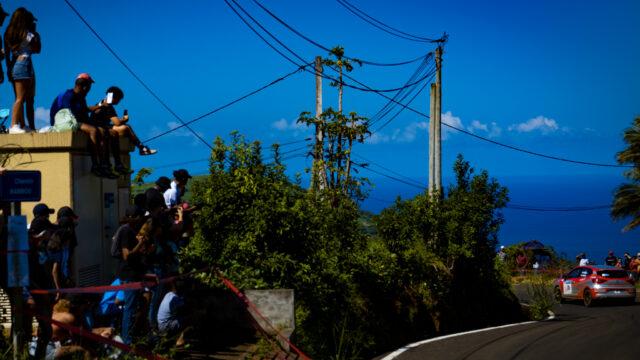 Une voiture de rallye devant des spectateurs