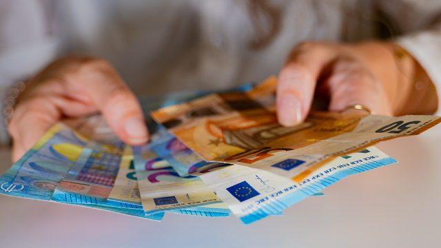 Des billets de banque tenus dans des mains