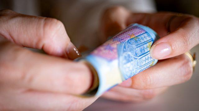 Des billets de banque tenus dans des mains