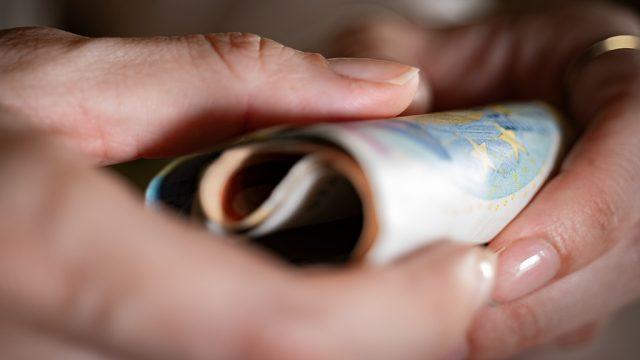 Des billets de banque tenus dans des mains
