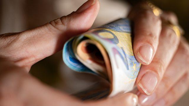 Des billets de banque tenus dans des mains