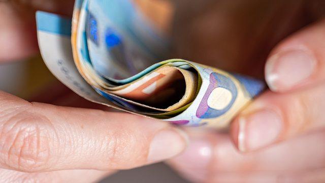 Des billets de banque tenus dans des mains