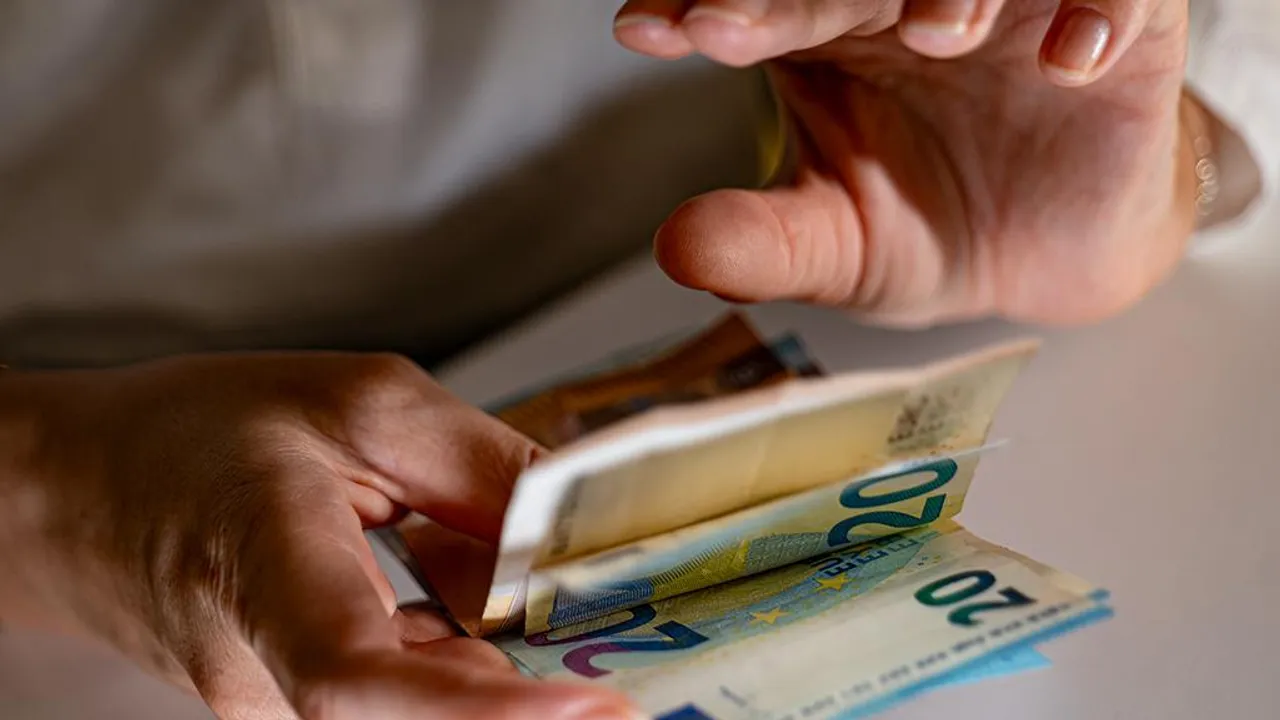 Des billets de banque tenus dans des mains