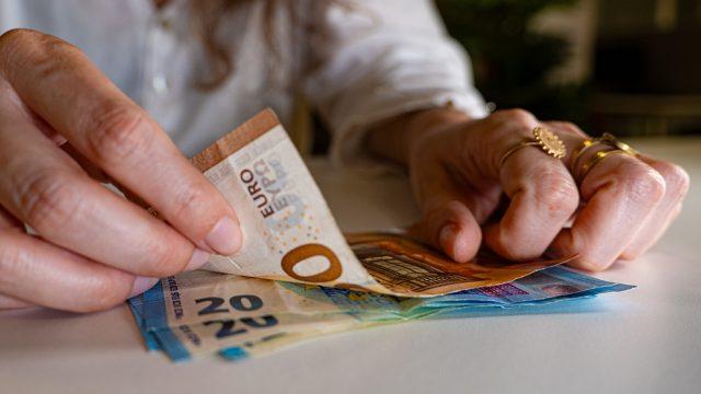 Des billets de banque tenus dans des mains