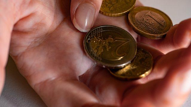 Des pièces de monnaie tenues dans une main