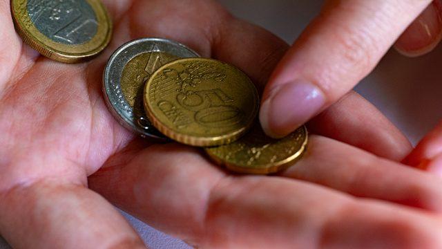 Des pièces de monnaie tenues dans une main