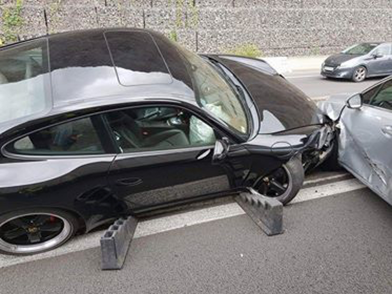 Carambolage sur la route du littoral: Une Porsche enjambe le muret central